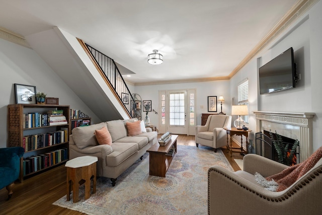 living room with ornamental molding, stairs, wood finished floors, and a premium fireplace
