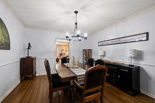 dining room with crown molding, baseboards, an inviting chandelier, and dark wood-type flooring