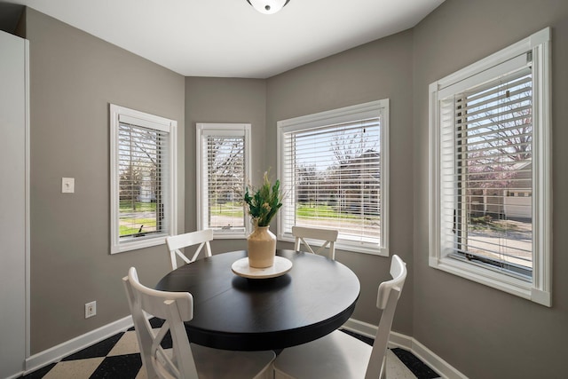 dining room with baseboards, a healthy amount of sunlight, and dark floors