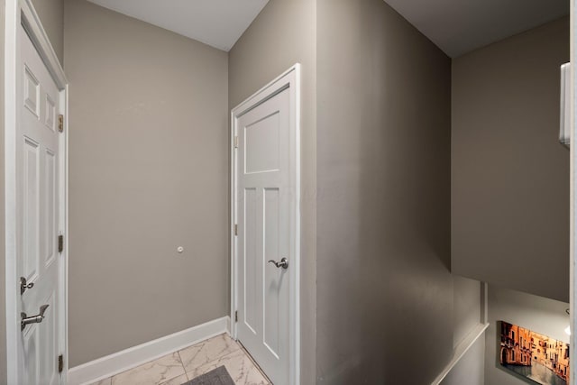 corridor featuring baseboards and marble finish floor