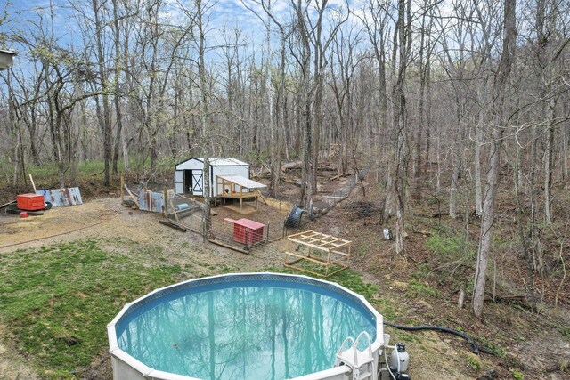 1335 Mingo Rd, Chillicothe, OH 45601 - view of pool featuring exterior structure, an outdoor structure, and a wooded view