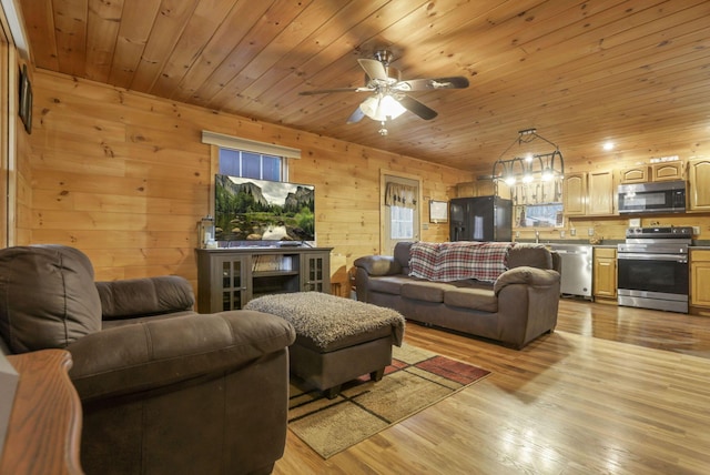 1335 Mingo Rd, Chillicothe, OH 45601 - living area with light wood-type flooring, ceiling fan, wood ceiling, and wood walls