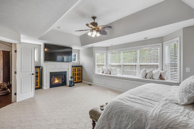 11061 Kingfisher Pl, Plain City, OH 43064 - carpeted bedroom featuring baseboards, ceiling fan, a glass covered fireplace, and a raised ceiling