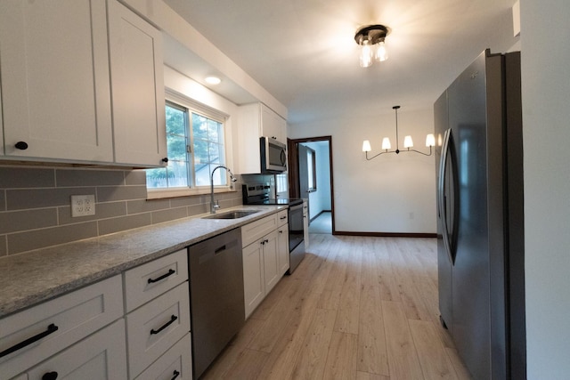 3161 Avalon Rd, Upper Arlington, OH 43221 - kitchen featuring appliances with stainless steel finishes, a chandelier, light wood-style flooring, and white cabinets