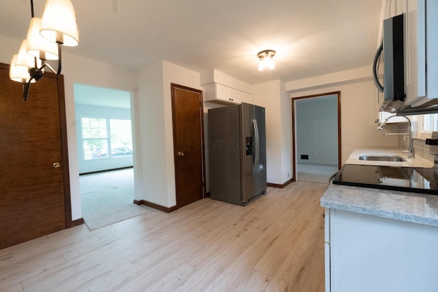 3161 Avalon Rd, Upper Arlington, OH 43221 - kitchen featuring black appliances, light wood-style flooring, white cabinets, light countertops, and pendant lighting