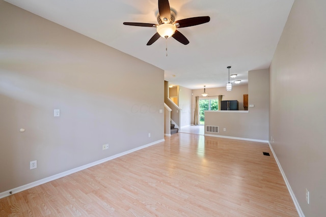 1218 Green Dr Unit 604, Columbus, OH 43230 - unfurnished living room featuring a ceiling fan, stairway, light wood-style floors, and baseboards