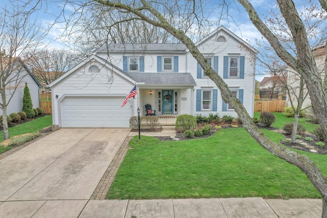 traditional-style home featuring a front yard, driveway, fence, and an attached garage