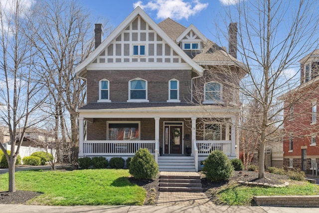 72 Miami Ave, Columbus, OH 43203 - view of front of house featuring a front lawn, a chimney, a porch, and brick siding