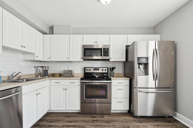 72 Miami Ave, Columbus, OH 43203 - kitchen featuring backsplash, a sink, dark wood-style floors, white cabinets, and appliances with stainless steel finishes