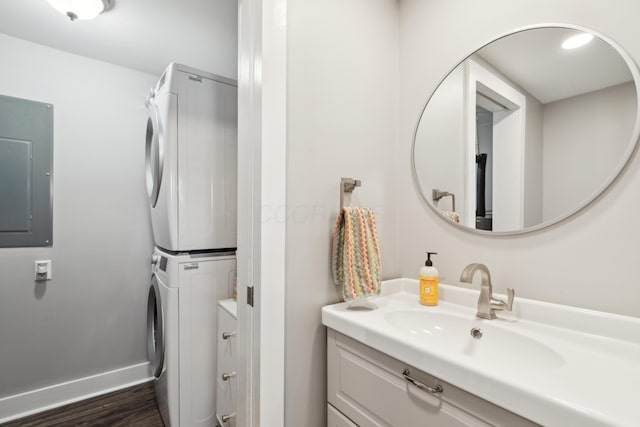 72 Miami Ave, Columbus, OH 43203 - bathroom with stacked washer / dryer, electric panel, baseboards, wood finished floors, and vanity