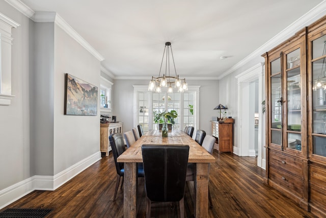 72 Miami Ave, Columbus, OH 43203 - dining room featuring crown molding, dark wood-type flooring, baseboards, a chandelier, and visible vents