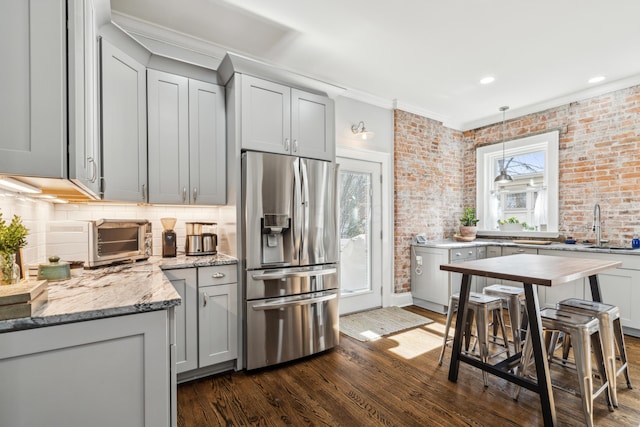 72 Miami Ave, Columbus, OH 43203 - kitchen with gray cabinets, backsplash, stainless steel fridge, brick wall, and dark wood-type flooring