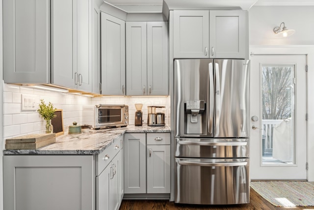 72 Miami Ave, Columbus, OH 43203 - kitchen featuring a toaster, light stone countertops, tasteful backsplash, stainless steel refrigerator with ice dispenser, and dark wood-style floors