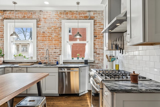 72 Miami Ave, Columbus, OH 43203 - kitchen with a sink, appliances with stainless steel finishes, brick wall, and wall chimney exhaust hood