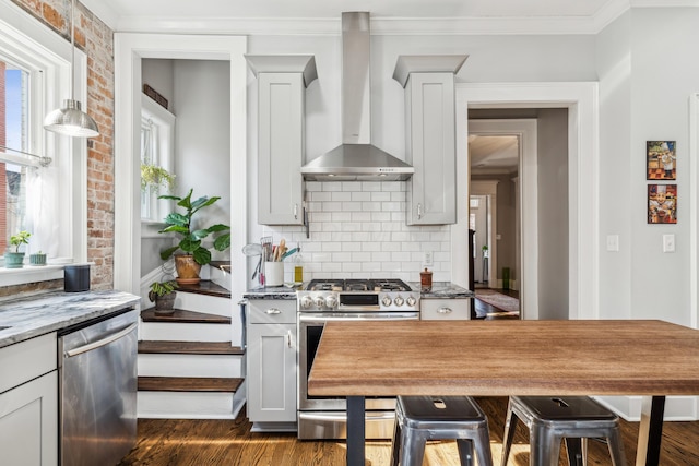 72 Miami Ave, Columbus, OH 43203 - kitchen featuring dark wood-style flooring, ornamental molding, wall chimney exhaust hood, and appliances with stainless steel finishes
