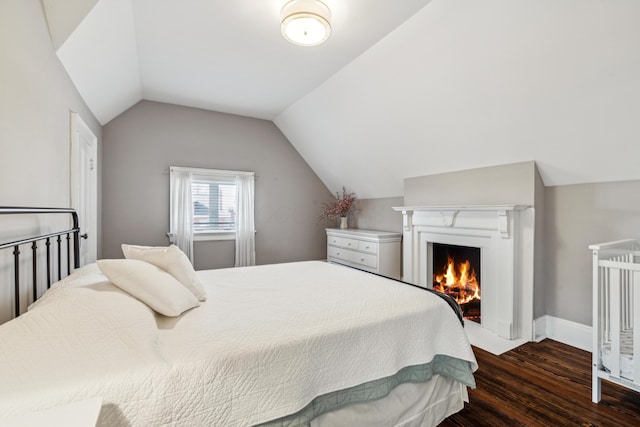 72 Miami Ave, Columbus, OH 43203 - bedroom featuring baseboards, lofted ceiling, a lit fireplace, and wood finished floors