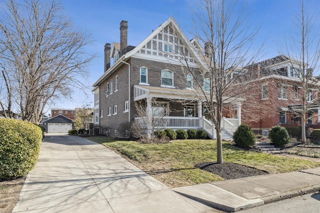 72 Miami Ave, Columbus, OH 43203 - view of front of property featuring an outbuilding, a front yard, covered porch, brick siding, and a chimney