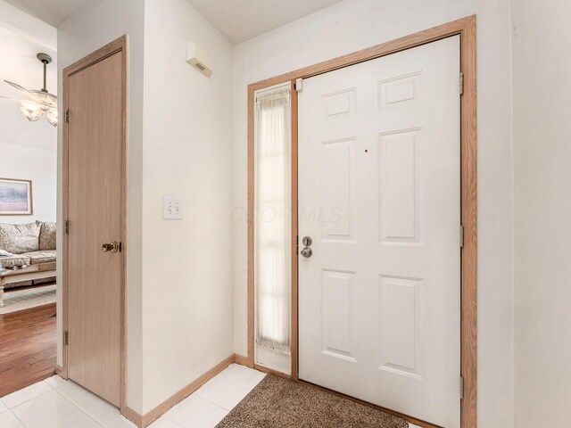 foyer featuring baseboards and light tile patterned floors