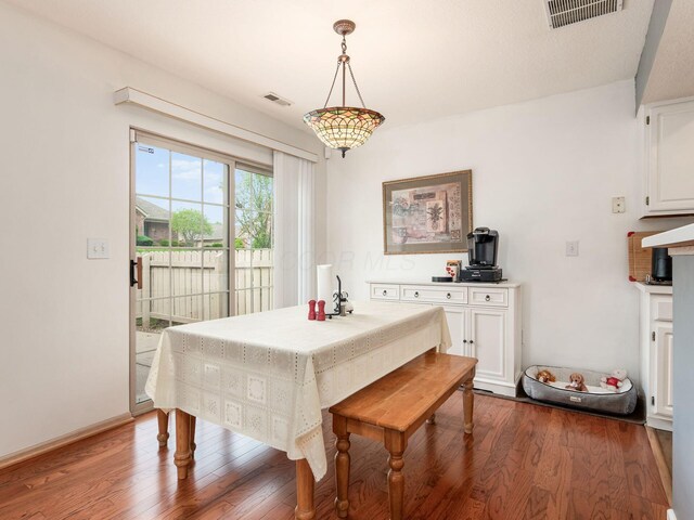 dining area with dark wood-style flooring and visible vents