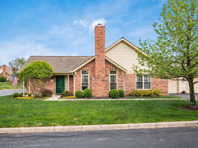 single story home with brick siding, a garage, a chimney, and a front lawn