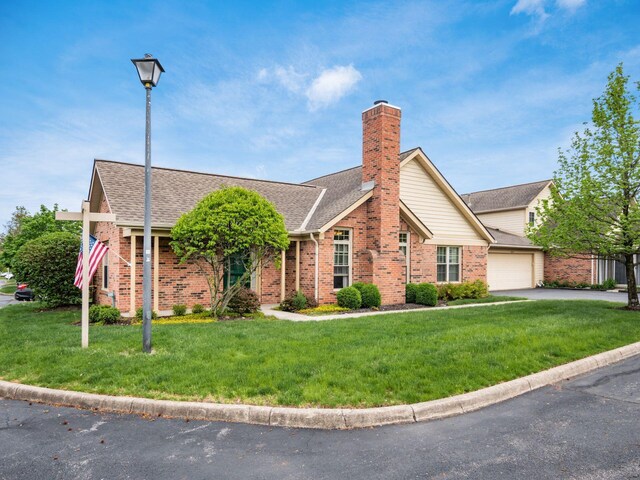 view of front of house with a garage, a front yard, driveway, and brick siding