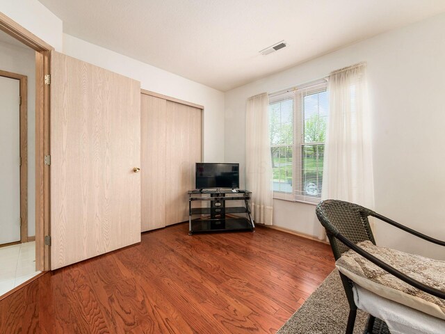 sitting room featuring visible vents, baseboards, and wood finished floors