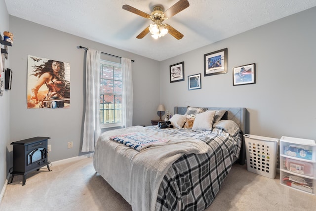 51 Township Rd Unit 1357, South Point, OH 45680 - carpeted bedroom with a wood stove, baseboards, a ceiling fan, and a textured ceiling