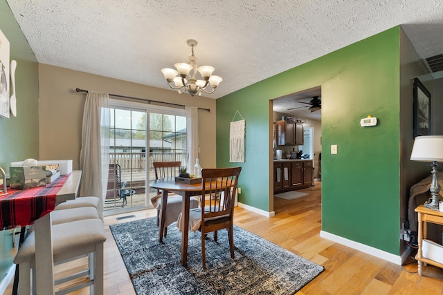 51 Township Rd Unit 1357, South Point, OH 45680 - dining area featuring a chandelier, light wood finished floors, a textured ceiling, a ceiling fan, and baseboards