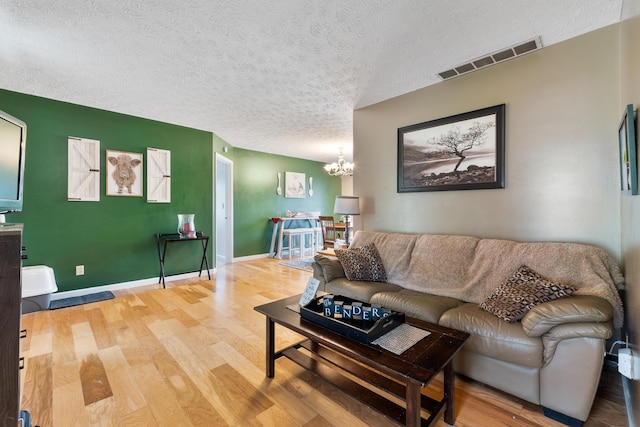 51 Township Rd Unit 1357, South Point, OH 45680 - living room featuring a chandelier, a textured ceiling, and wood finished floors