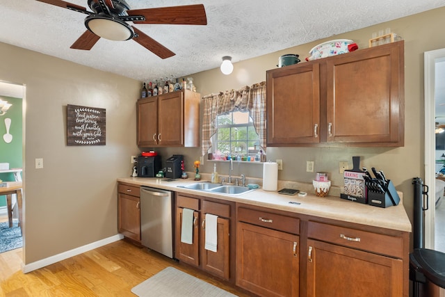 51 Township Rd Unit 1357, South Point, OH 45680 - kitchen featuring stainless steel dishwasher, a sink, light wood-style flooring, light countertops, and brown cabinetry