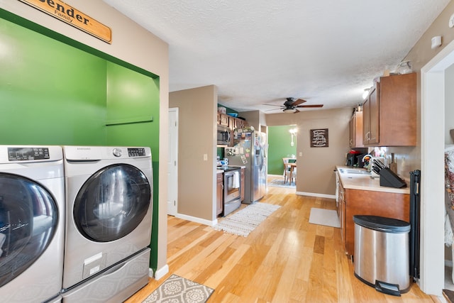 51 Township Rd Unit 1357, South Point, OH 45680 - laundry room featuring washer and clothes dryer, a ceiling fan, light wood-style flooring, a textured ceiling, and baseboards
