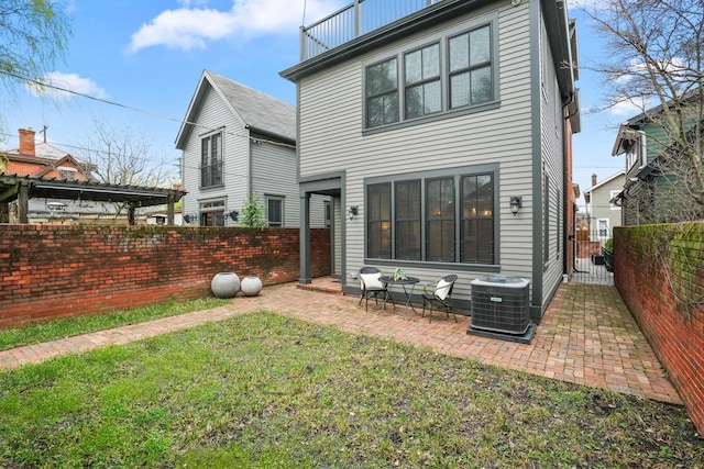 324 Jackson St, Columbus, OH 43206 - rear view of house featuring a lawn, fence private yard, central air condition unit, and a patio