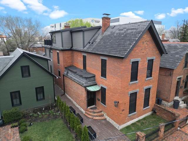 324 Jackson St, Columbus, OH 43206 - rear view of property featuring a chimney, fence, brick siding, and roof with shingles