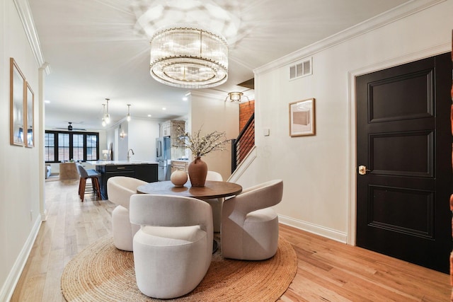 324 Jackson St, Columbus, OH 43206 - dining space featuring light wood-style flooring, crown molding, baseboards, and visible vents