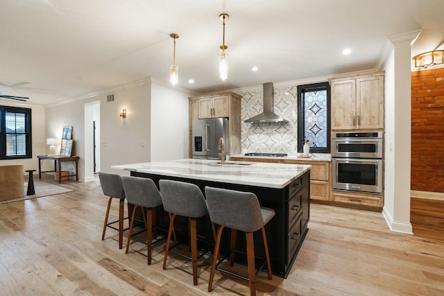324 Jackson St, Columbus, OH 43206 - kitchen with a sink, light wood-style flooring, stainless steel appliances, wall chimney range hood, and visible vents