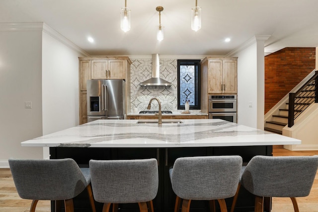324 Jackson St, Columbus, OH 43206 - kitchen featuring decorative backsplash, light wood finished floors, wall chimney exhaust hood, stainless steel appliances, and light brown cabinets
