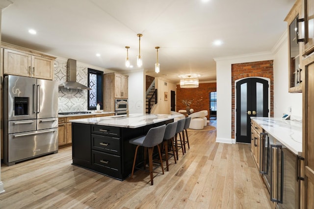 324 Jackson St, Columbus, OH 43206 - kitchen with light wood-type flooring, ornamental molding, stainless steel appliances, decorative backsplash, and wall chimney exhaust hood