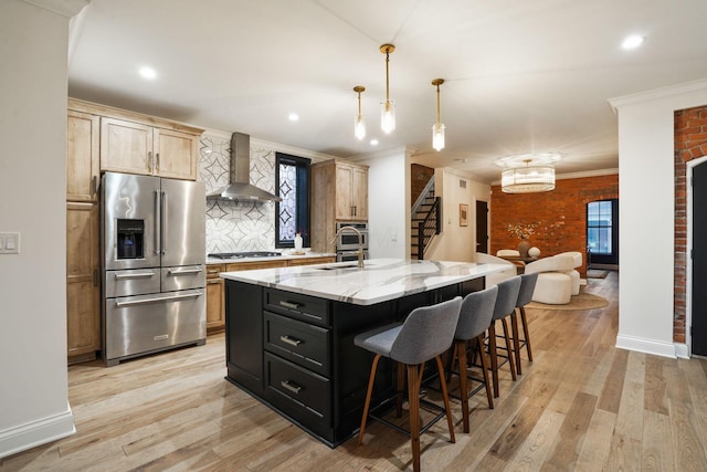 324 Jackson St, Columbus, OH 43206 - kitchen with ornamental molding, wall chimney range hood, light wood finished floors, and appliances with stainless steel finishes