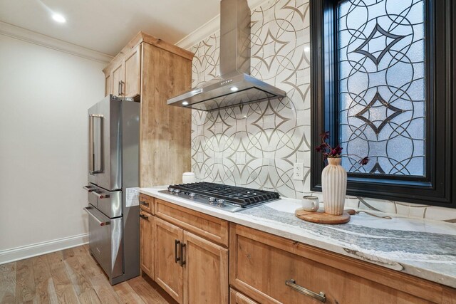 324 Jackson St, Columbus, OH 43206 - kitchen with crown molding, light wood finished floors, light stone countertops, stainless steel appliances, and wall chimney exhaust hood
