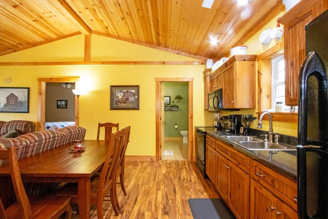 kitchen with lofted ceiling, wooden ceiling, a sink, dark countertops, and black appliances