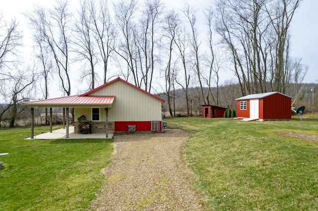 view of yard with an outbuilding, a shed, and a patio area