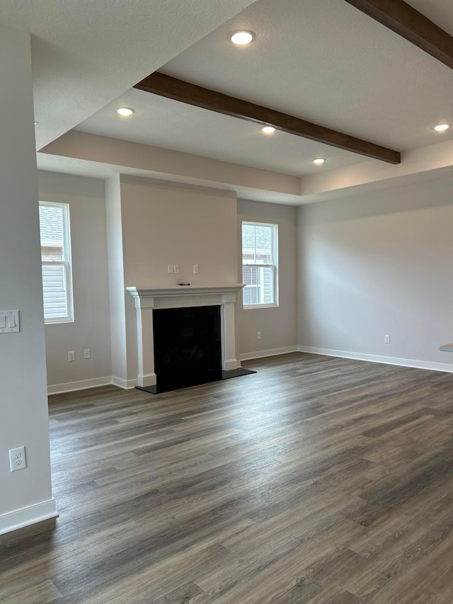 unfurnished living room with baseboards, a fireplace, recessed lighting, dark wood finished floors, and beam ceiling