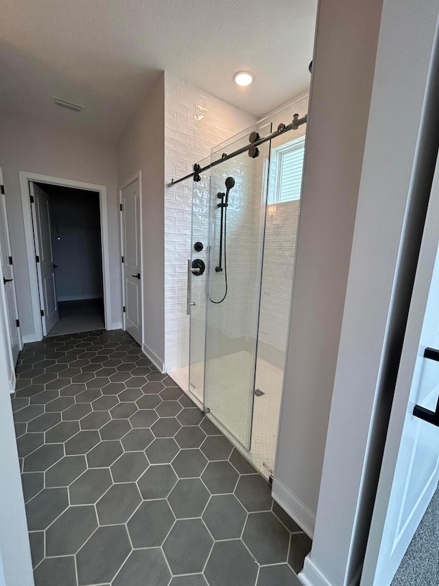 full bathroom featuring a stall shower, baseboards, and visible vents