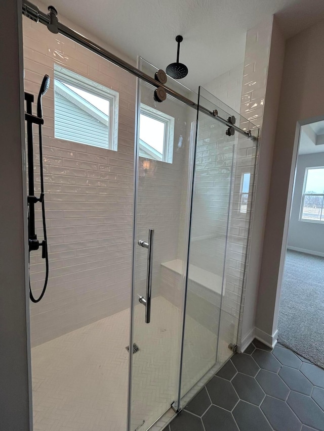 bathroom with tile patterned flooring, a stall shower, and baseboards
