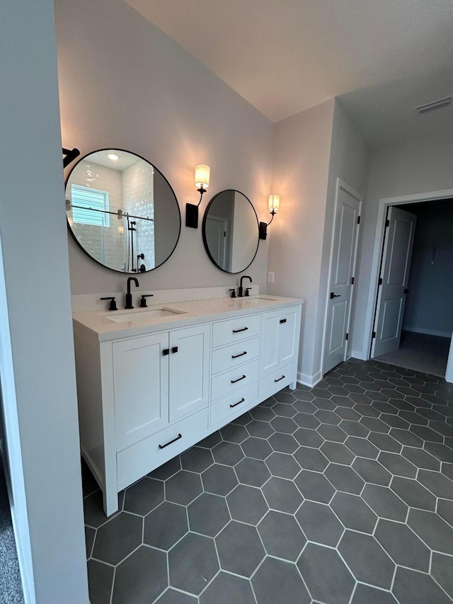 full bathroom featuring double vanity, a sink, visible vents, and a shower stall