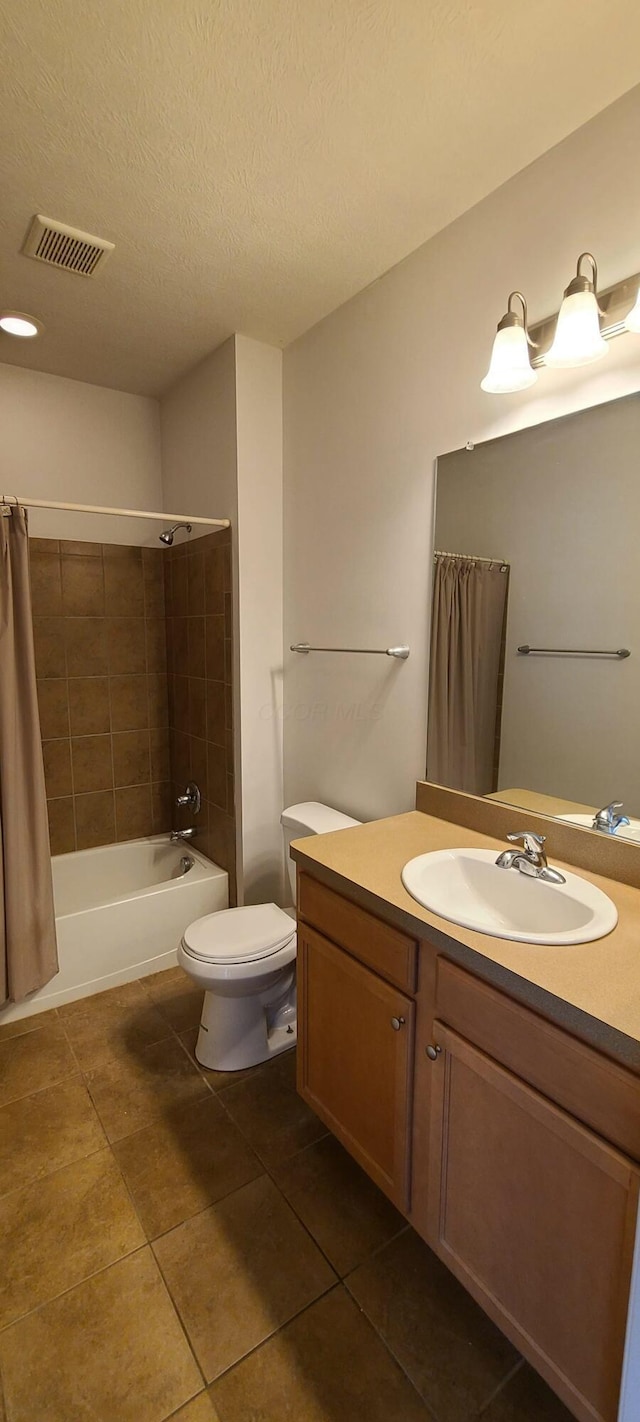 bathroom with tile patterned floors, a textured ceiling, toilet, visible vents, and vanity