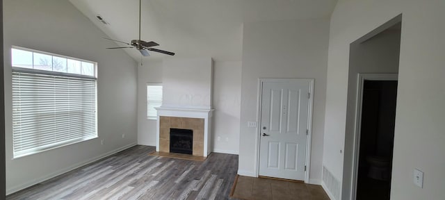 unfurnished living room with a fireplace, a wealth of natural light, a ceiling fan, and visible vents