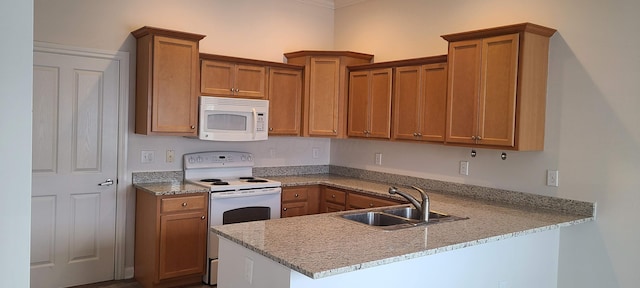 6897 Rothwell St, New Albany, OH 43054 - kitchen featuring white appliances, a peninsula, brown cabinets, and light stone counters