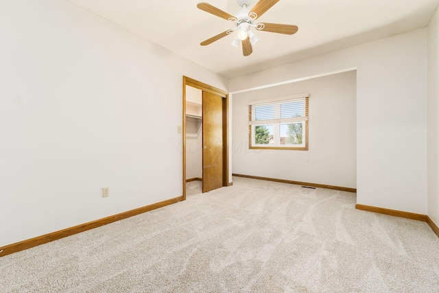 unfurnished bedroom with visible vents, a closet, baseboards, light colored carpet, and a ceiling fan