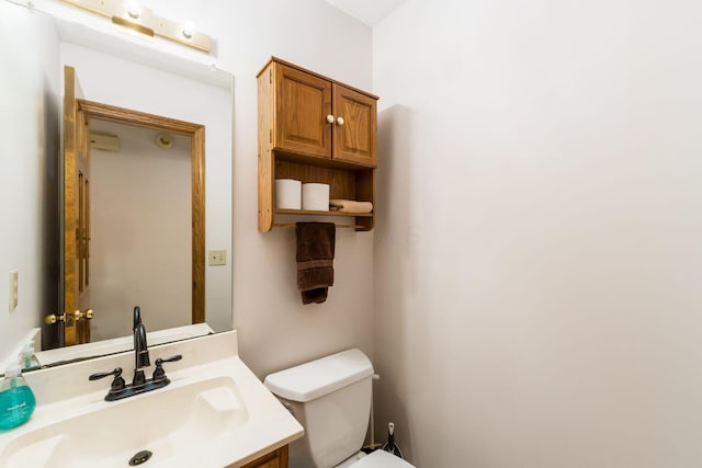 half bathroom with vanity and toilet